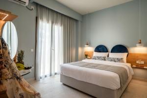a bedroom with a large bed and a large window at Syvota Gardens in Syvota