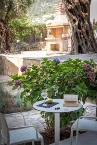 a table with a glass of wine and a book at Syvota Gardens in Syvota