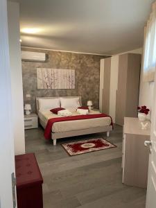 - une chambre avec un lit et une couverture rouge dans l'établissement B&b armonia, à Ugento