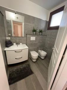 La salle de bains est pourvue d'un lavabo, de toilettes et d'un miroir. dans l'établissement B&b armonia, à Ugento