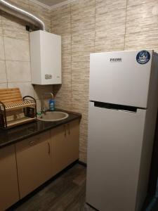 a kitchen with a white refrigerator and a sink at Apart Perspektivna in Kropyvnytskyi