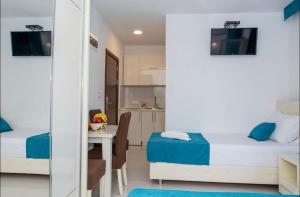 a small bedroom with two beds and a table at Apartmani Nela Sutomore in Sutomore