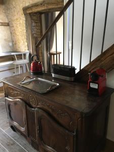 a wooden table with a tea kettle on top of it at Gîte de la Roseraie in Ceton