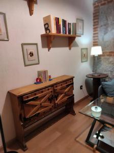 un soggiorno con cassettiera in legno e libri. di Casa Rural Puerta de Castilla a Velayos