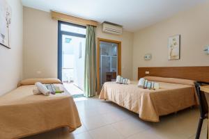 Posteľ alebo postele v izbe v ubytovaní Hostal Costabella powered by Faro Homes