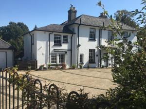 a white house with a fence in front of it at Little Treasure and Gem with private 2 person Hot Tub and up to 25 percent ferry saving in Shanklin