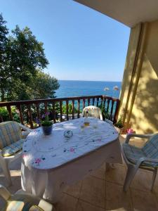 Villa Zisi في Livadáki: طاولة وكراسي على شرفة مع المحيط