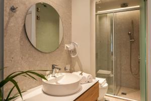 a bathroom with a sink and a toilet and a mirror at Syvota Gardens in Syvota