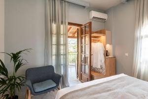 a bedroom with a bed and a chair and a mirror at Syvota Gardens in Syvota