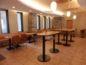 金沢市にあるR&B Hotel Kanazawa Station Nishiguchi - Vacation STAY 39073vの木製のテーブルと椅子と窓のあるレストラン +8枚の写真
