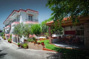 a house with a patio and a table in front of it at Marmaron Rooms in Agiokampos