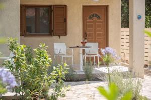 a patio with chairs and a table in front of a door at Syvota Gardens in Syvota