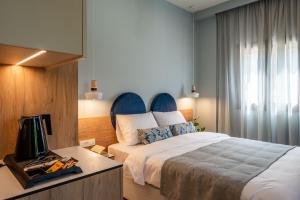 a bedroom with a bed and a desk with a television at Syvota Gardens in Sivota