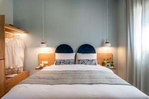 a bedroom with a large bed with a blue headboard at Syvota Gardens in Syvota