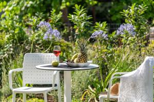 a table with a bowl of fruit and a glass of wine at Syvota Gardens in Syvota
