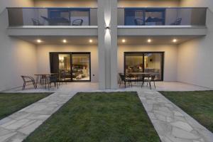 a house with a patio with tables and chairs at MOLA PAPAYA STUDIOS in Mola Kalyva