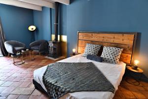 a bedroom with a large bed and a blue wall at Le Bruit de l'Eau (Chambre La Suite) in Labeaume