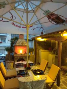 カヴァラにあるKIKI APARTMENTのテーブル(黄色い椅子、傘付)