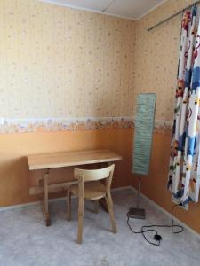 a table and a chair and a lamp in a room at Homestay cozy hosting in Tervakoski