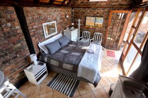 a bedroom with a bed in a brick wall at Riverstay in Kroonstad