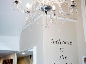 a chandelier with the words welcome to the office at The Chocolate Box Hotel in Bournemouth