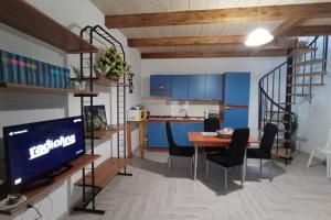 une cuisine et une salle à manger avec des armoires bleues et une table dans l'établissement B&B la piccola maison, à Ploaghe