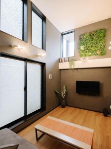 uma sala de estar com janelas grandes e uma televisão em REQRAS Sakuramachi - Vacation STAY 52733v em Kumamoto