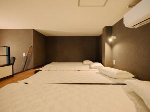 a row of beds in a room at REQRAS Sakuramachi - Vacation STAY 52733v in Kumamoto