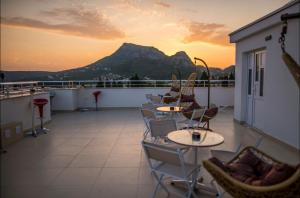 a balcony with tables and chairs and a mountain at Apartmani Nela Sutomore in Sutomore