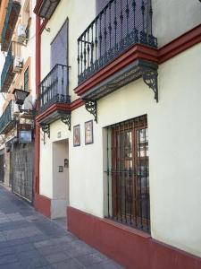 a building with balconies on the side of a street at Apartamentos y lofts en Triana in Seville