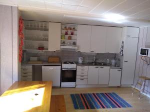 een keuken met witte kasten en een wastafel bij Oliveira Guesthouse in Tohkala
