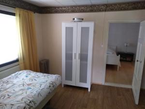 een slaapkamer met een bed en een kast met een spiegel bij Oliveira Guesthouse in Tohkala