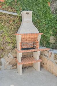 a brick oven sitting on top of a bench at Casa dos Cabecinhos in Oliveira do Hospital