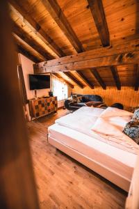 Cama grande en habitación con techo de madera en DESIGn und FERIEN HOTEL CHRISTANIA en Fiesch