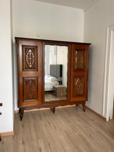 a wooden cabinet with a mirror in a room at Gîtes des châteaux - gite A in Selles-sur-Cher