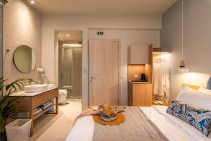 a bedroom with a bed and a bathroom with a sink at Syvota Gardens in Syvota