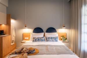 a bedroom with a large bed with blue and white pillows at Syvota Gardens in Syvota