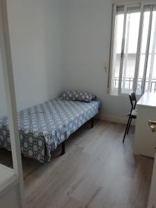 a small bedroom with a bed and a window at Habitaciónes Luminosas y acogedoras in Madrid