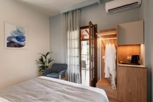a bedroom with a bed and a chair and a window at Syvota Gardens in Syvota