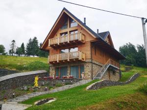 ein Holzhaus mit Balkon auf einem Hügel in der Unterkunft STONEGALLERY in Ždiar