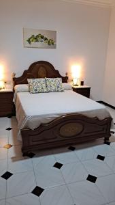 a bedroom with a large wooden bed with two lamps at Casa El Villa in Zahara de la Sierra