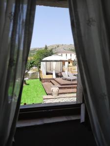 una ventana con vistas a un patio trasero con cenador en B&B Palazzo La Loggia, en Barisciano