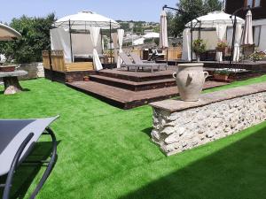 a backyard with a lawn with chairs and umbrellas at B&B Palazzo La Loggia in Barisciano