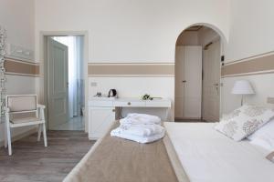 a white bedroom with a bed and a desk at Hotel Olimpia in Forte dei Marmi