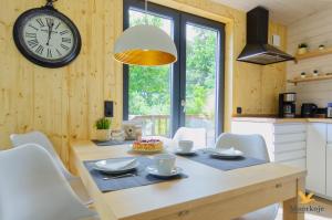 ein Esszimmer mit einem Tisch und einer Uhr an der Wand in der Unterkunft Moorkoje Worpswede in Worpswede