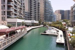 a river in a city with buildings and a bridge at Bright and central 2 bedroom flat in Gibraltar in Gibraltar