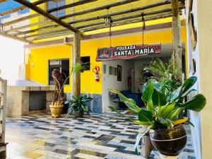 a building with potted plants in front of it at Pousada Santa Maria in Aparecida