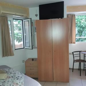 duża drewniana szafka w sypialni z oknami w obiekcie Ground Floor Studio Galini w Retimnie +32 zdjęcia