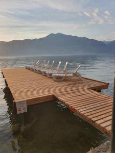 eine Gruppe von Stühlen auf einem Dock im Wasser in der Unterkunft Hotel Merano in Brenzone sul Garda