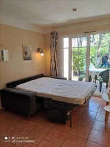 a hospital bed in a room with a large window at Maisonnette mitoyenne 2 étoiles paisible piscine océan lac vélo marche idéal pour tous in Lacanau-Océan